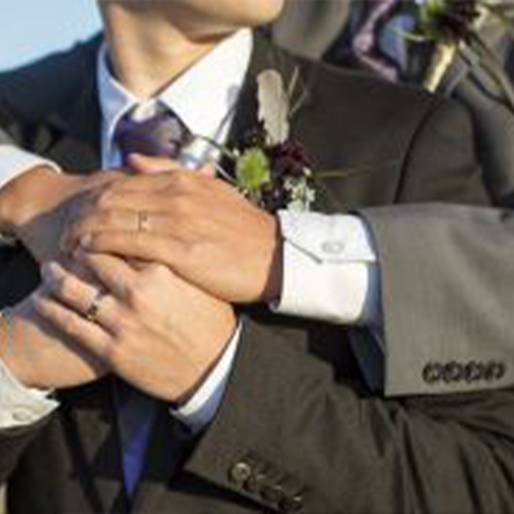 Two men embrace for a wedding photo