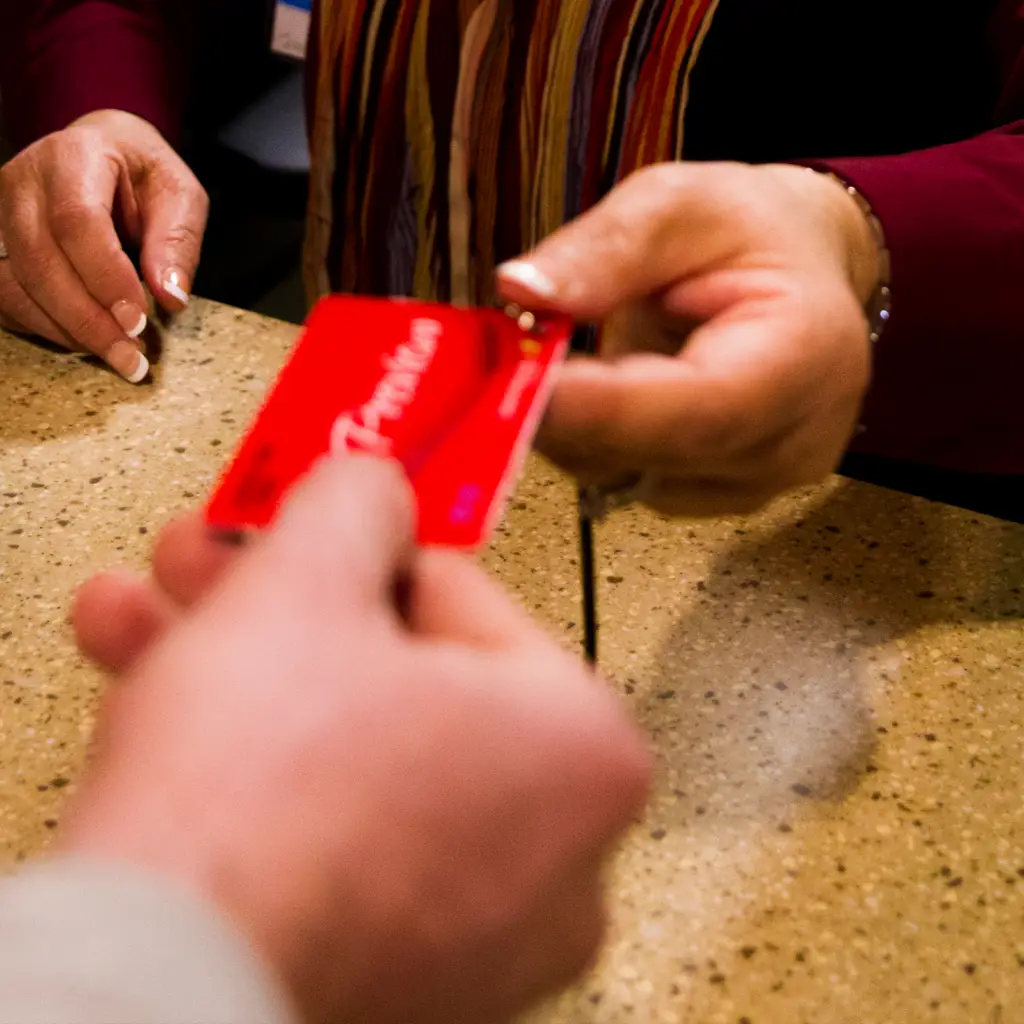 Two people handing each other a players card