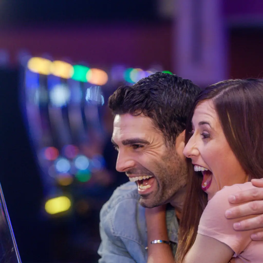 A couple excited at the slot machines