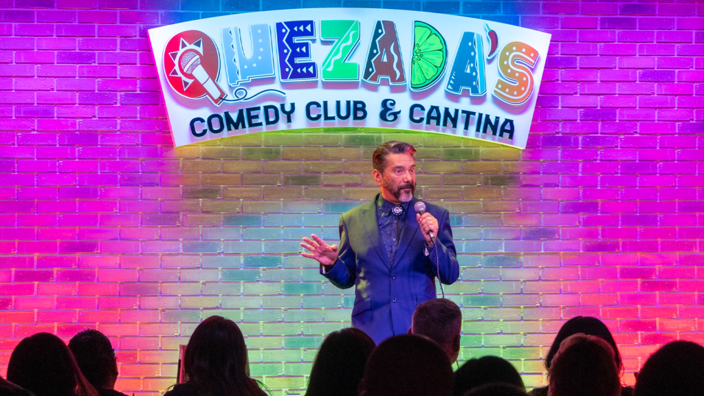 Steven Michael Quezada standing on a stage