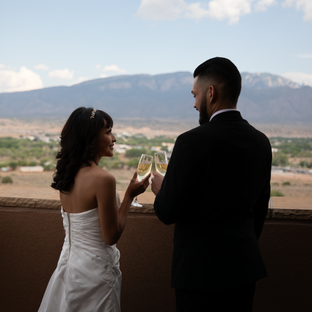 Married couple looking out over a view of the sandia mountains